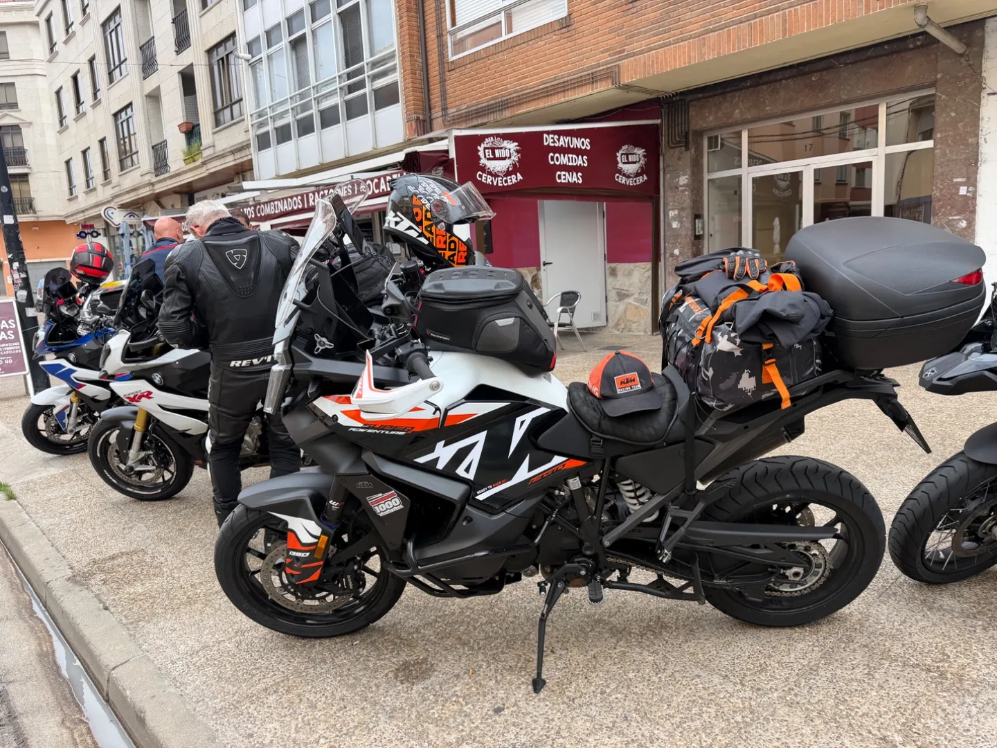 Loaded touring motorcycles parked outside a cafe during a coffee stop in Villarcayo, Burgos