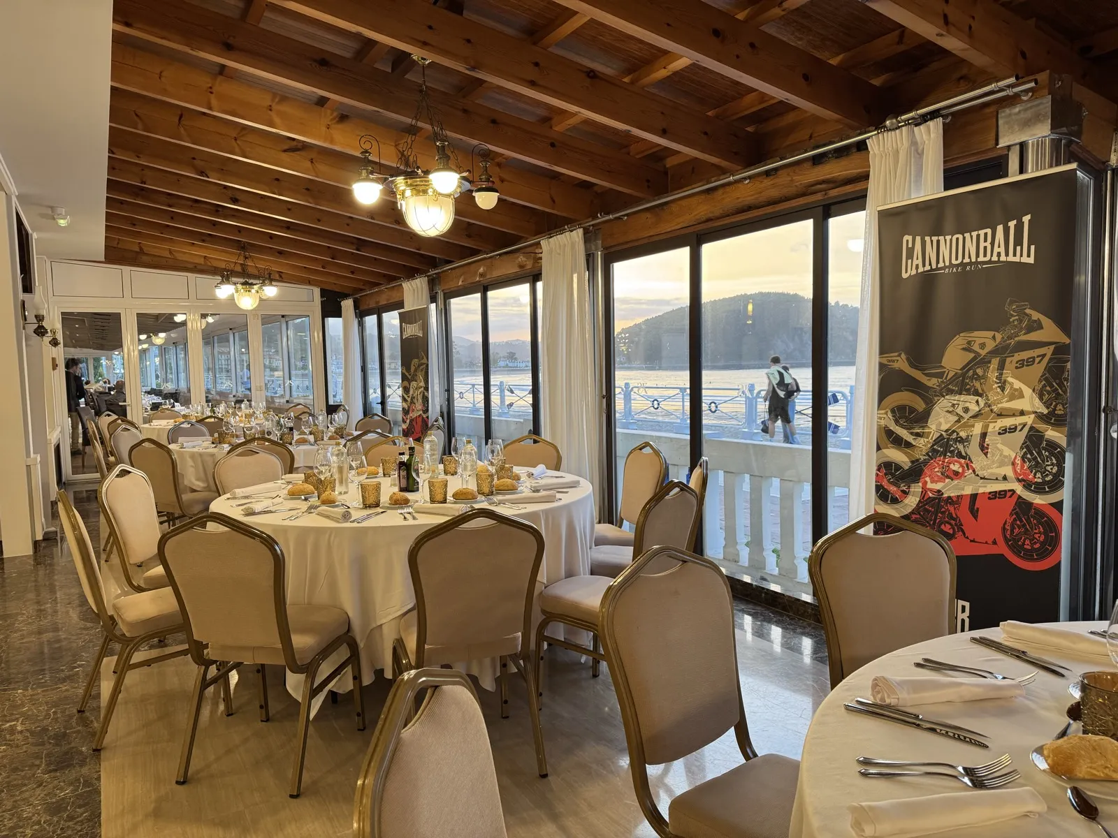 The Cannonball dinner room in Ribadesella, with tables set and sea views through the windows