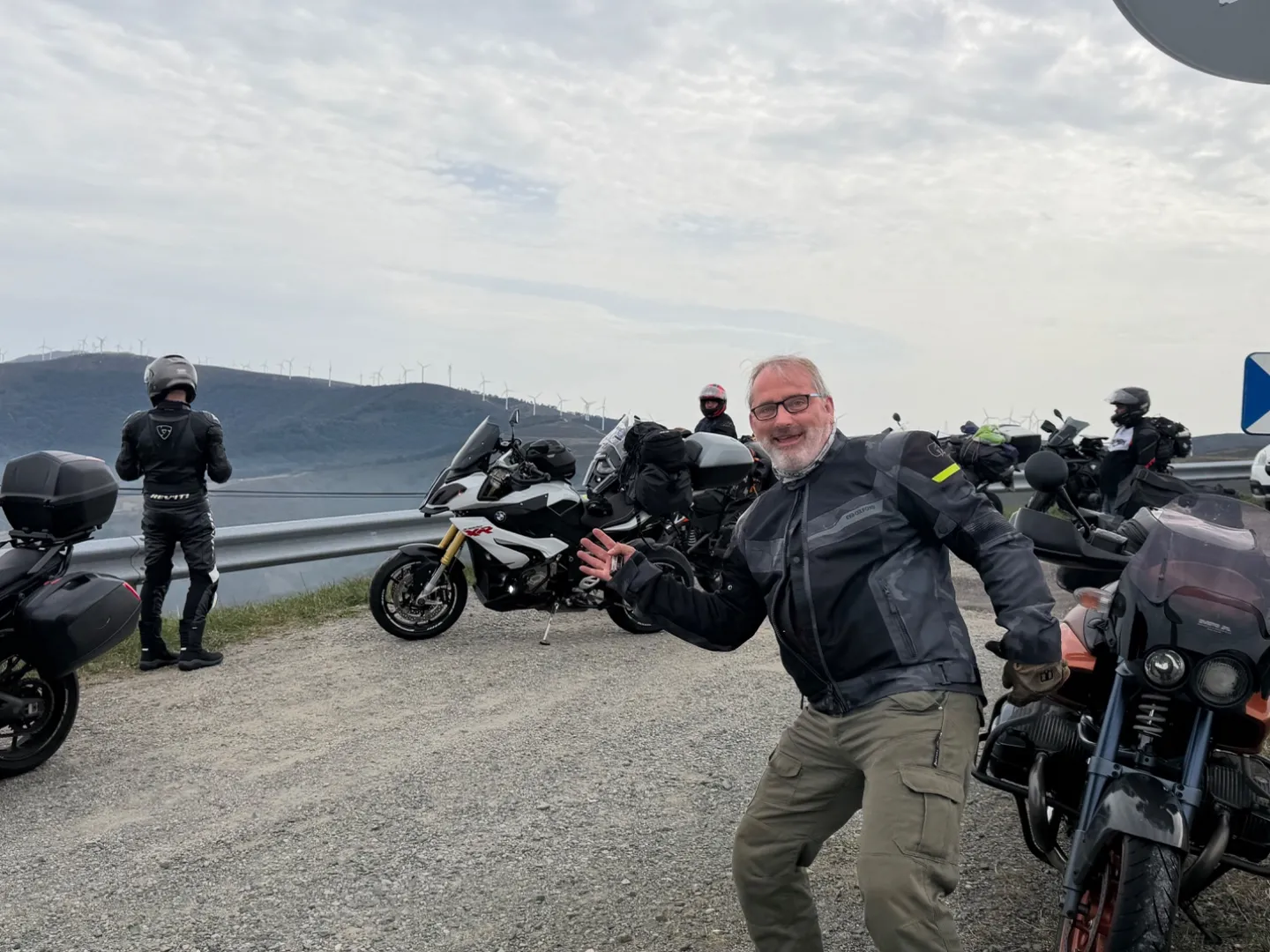 Cannonball riders and motorcycles regrouping at a mountain viewpoint in northern Spain