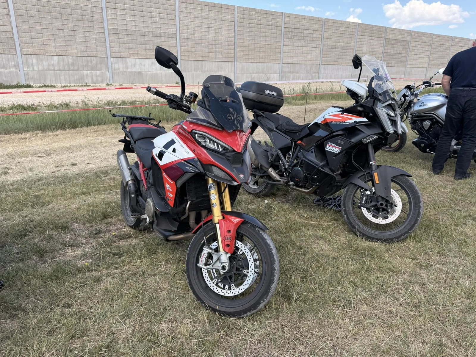 Jim Horne's Ducati Multistrada V4 Pikes Peak and Alan Jones' KTM 1390 Super Adventure S Evo in Cannonball livery, parked side by side at the Hungarian MotoGP
