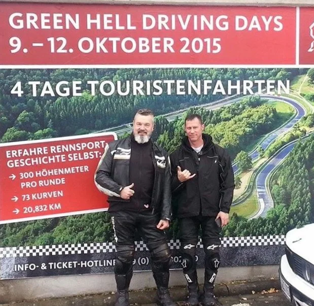 Alan Jones and Jeremy Simmons in front of a Green Hell Driving Days sign at the Nurburgring