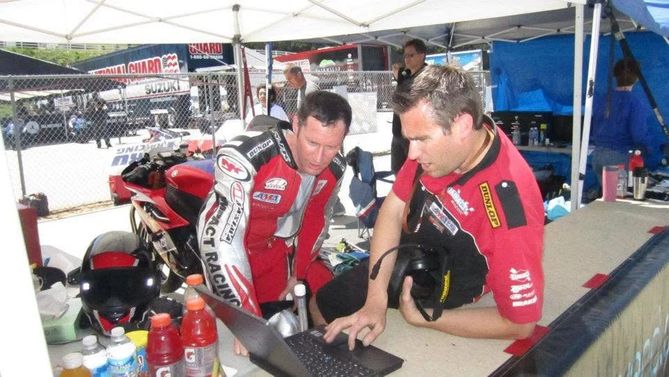 Jeremy Simmons and his crew member Corey checking data on a laptop in the pits