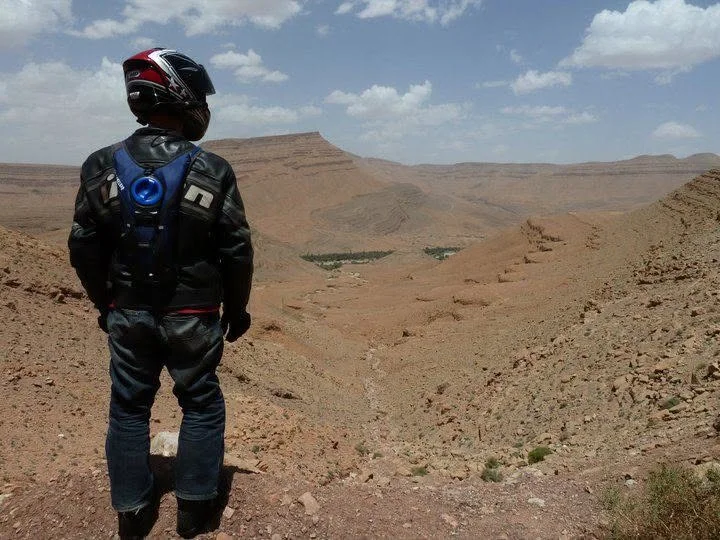 Jeremy Simmons in riding gear looking out over the Moroccan desert landscape