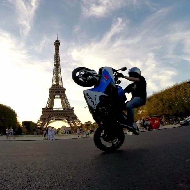 Jeremy Simmons wheelieing a motorcycle in front of the Eiffel Tower in Paris