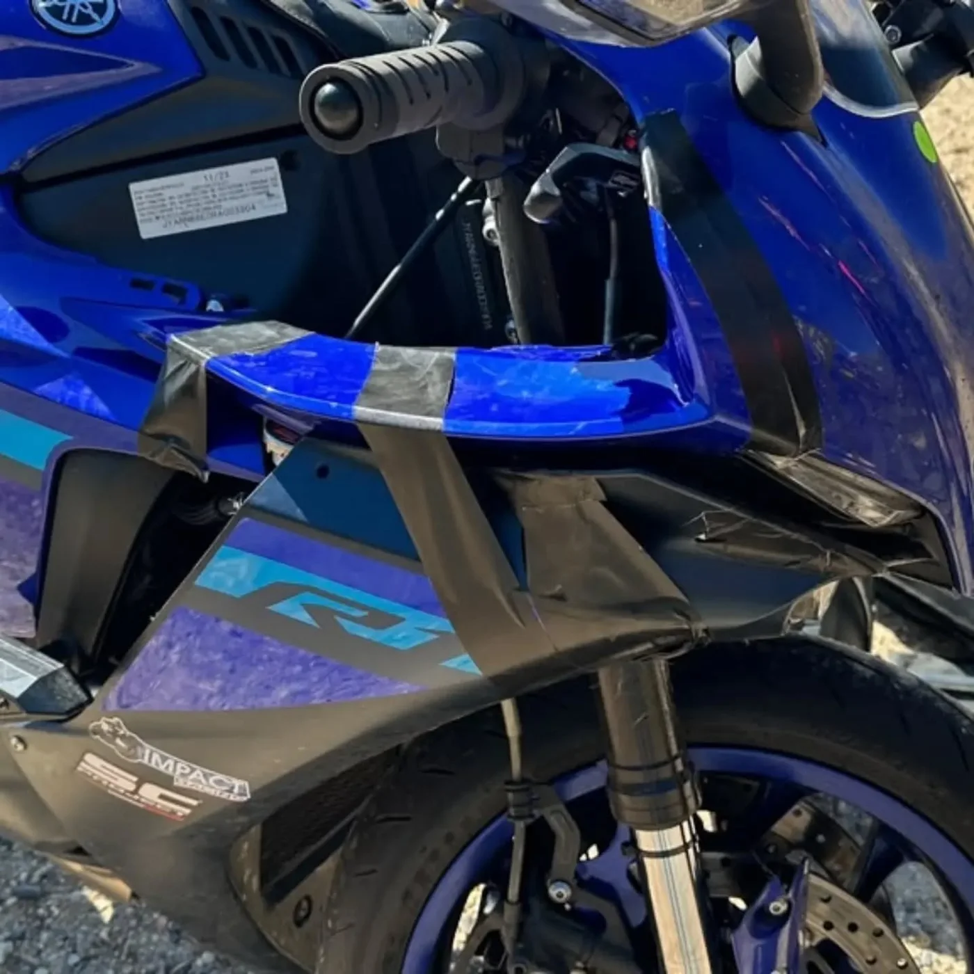 Blue Yamaha R1 fairing held together with tape after a roadside repair