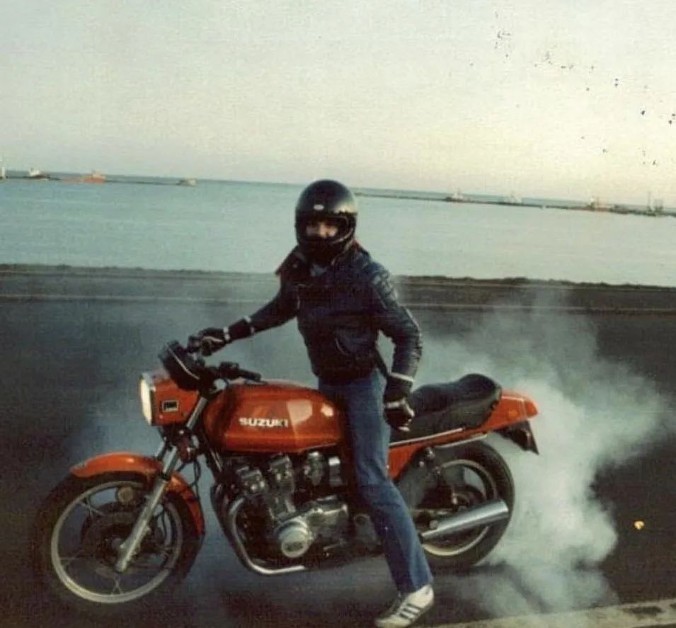 Jim Horne doing a burnout on a classic orange Suzuki by the sea in the early days