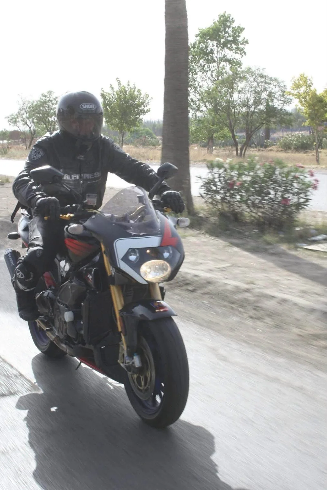 Jim Horne riding his motorcycle on a wet road