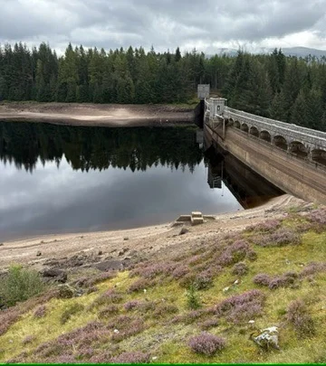 Laggan Dam and its reservoir on the A86 with heather in the foreground