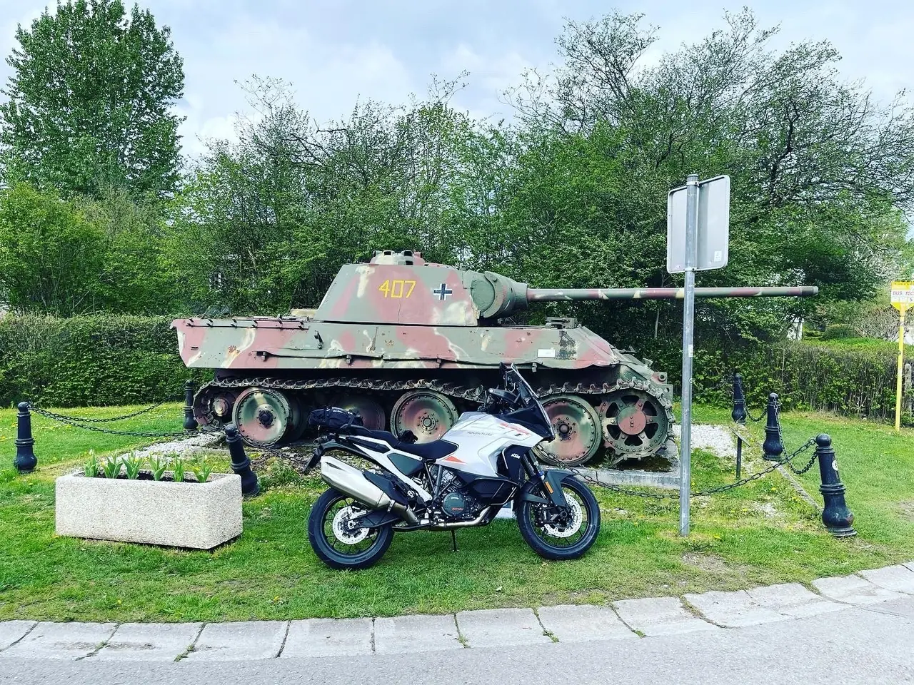 KTM parked in front of the Panther Ausf. G tank monument with turret number 407 at the Grandmenil crossroads near Manhay