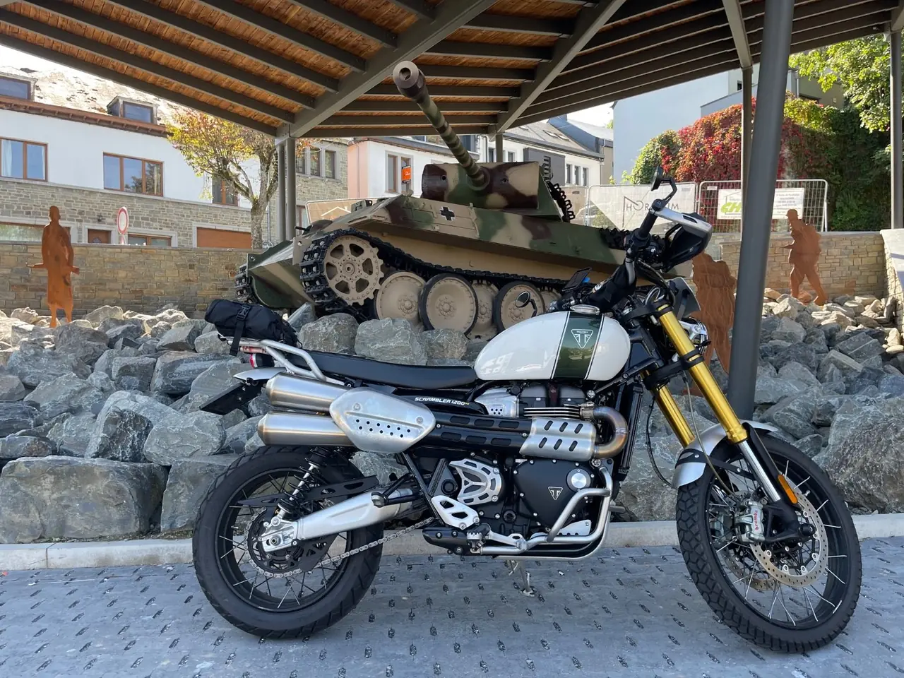 Triumph Scrambler 1200 parked in front of the restored Panther Ausf. G tank under its new roof at Houffalize