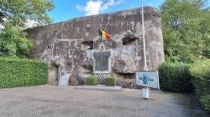 The concrete entrance block of Fort de Battice, with the Belgian flag flying above the memorial